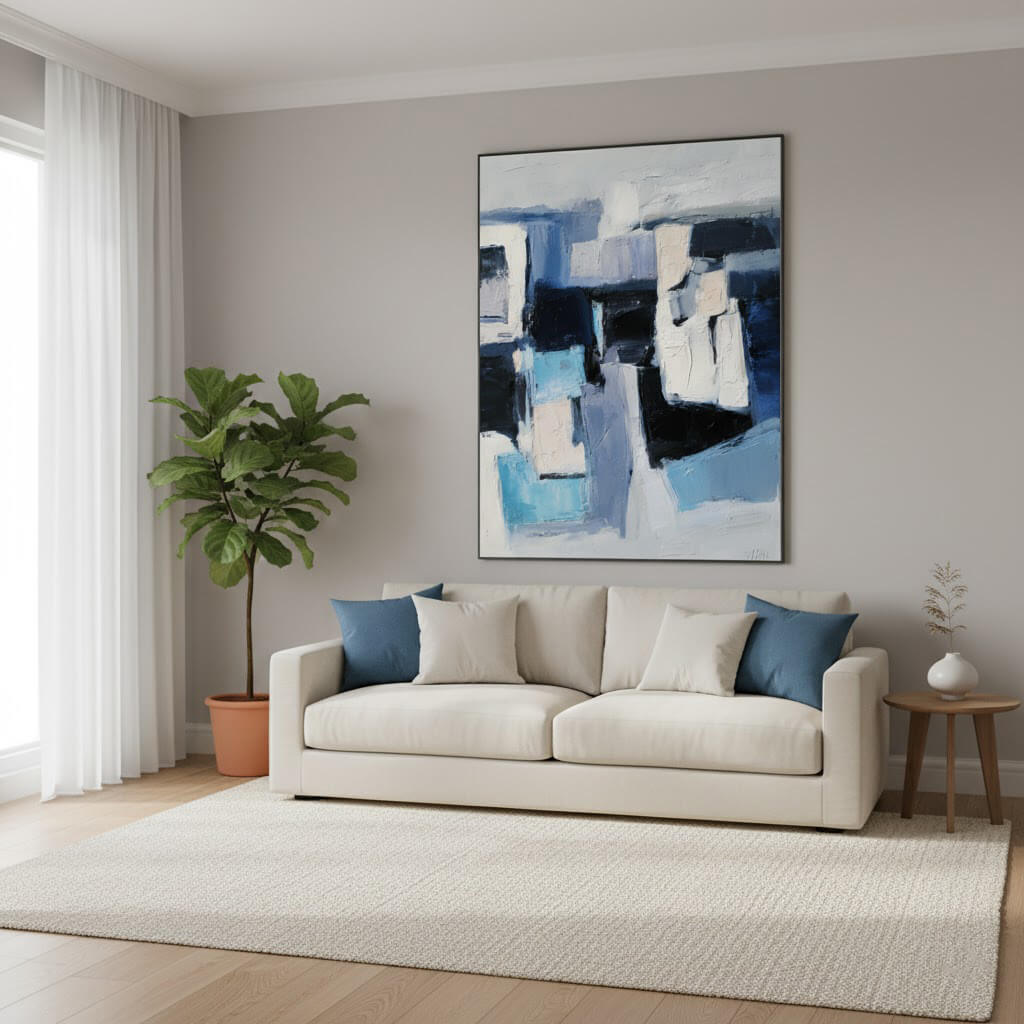 Modern living room with a beige sofa, abstract painting, and potted plant.