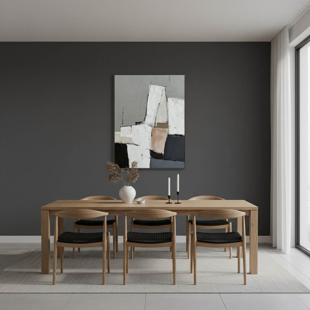 Dining room with wooden table and chairs against a dark gray wall with abstract art.