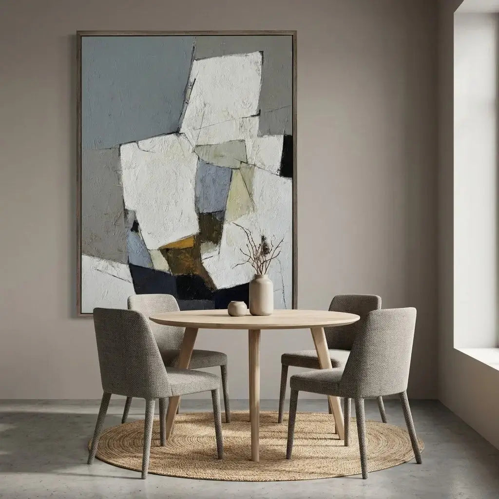 Dining room with round wooden table and chairs, abstract art on the wall.