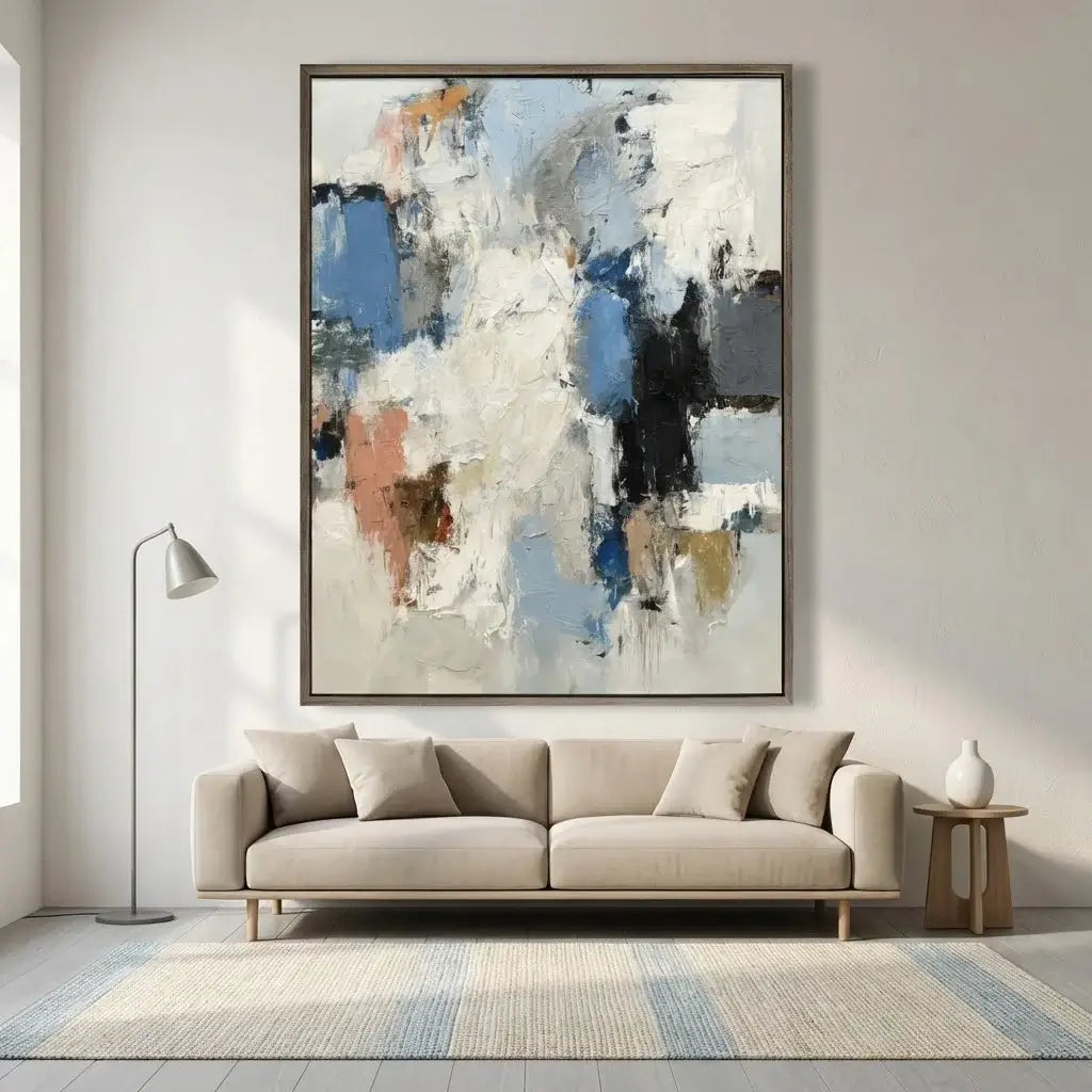 Abstract painting on a wall above a beige sofa in a living room.