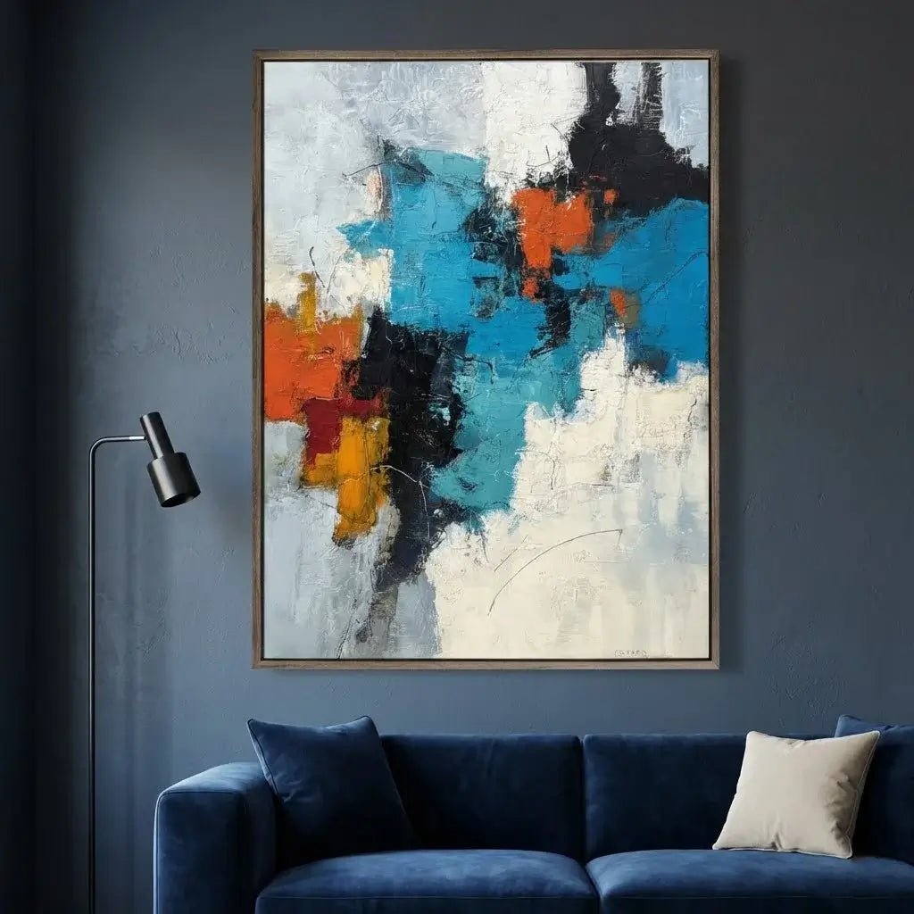 Abstract painting with blue, orange, and black colors on a dark wall above a blue sofa.