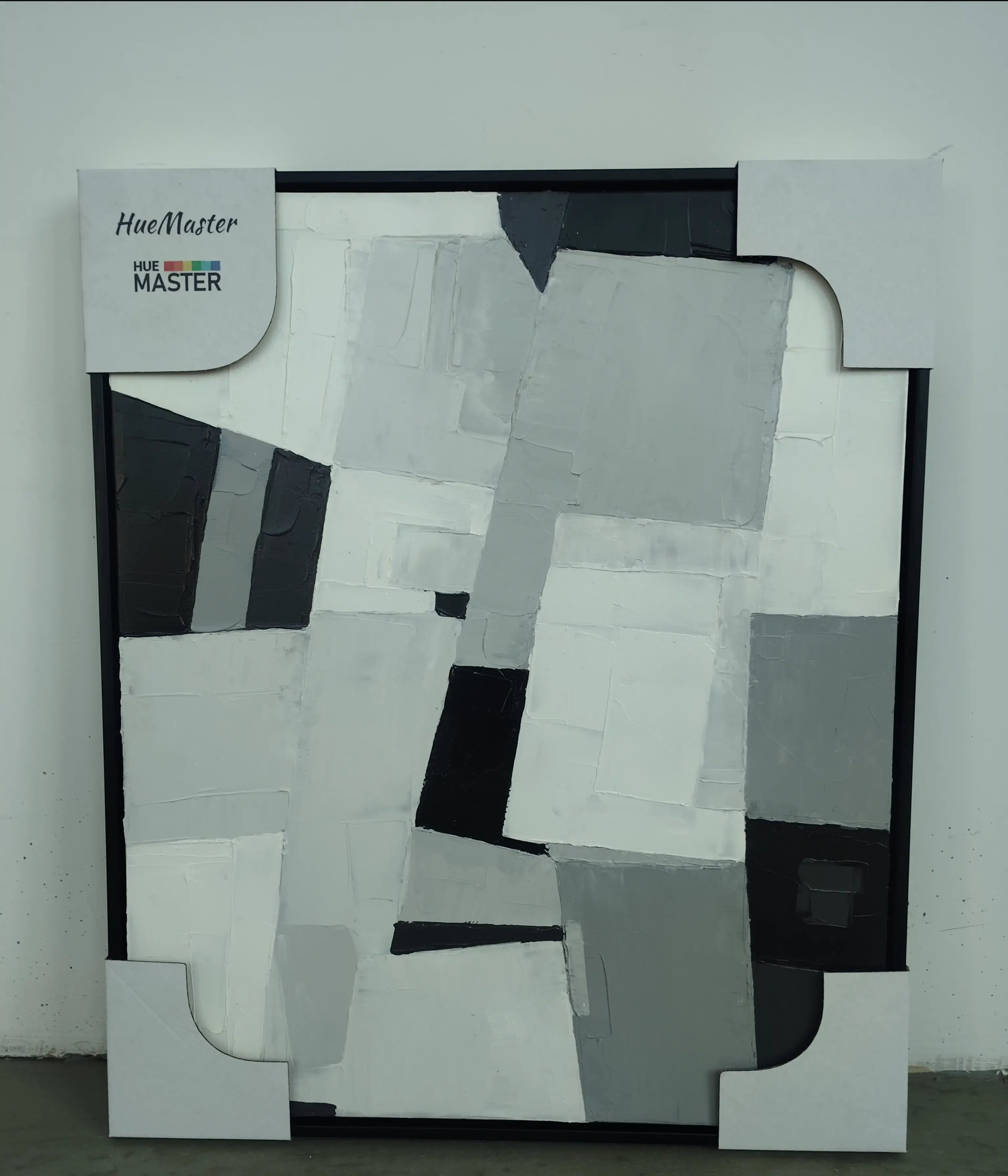 Abstract art piece with geometric shapes in black, white, and gray on a white background.