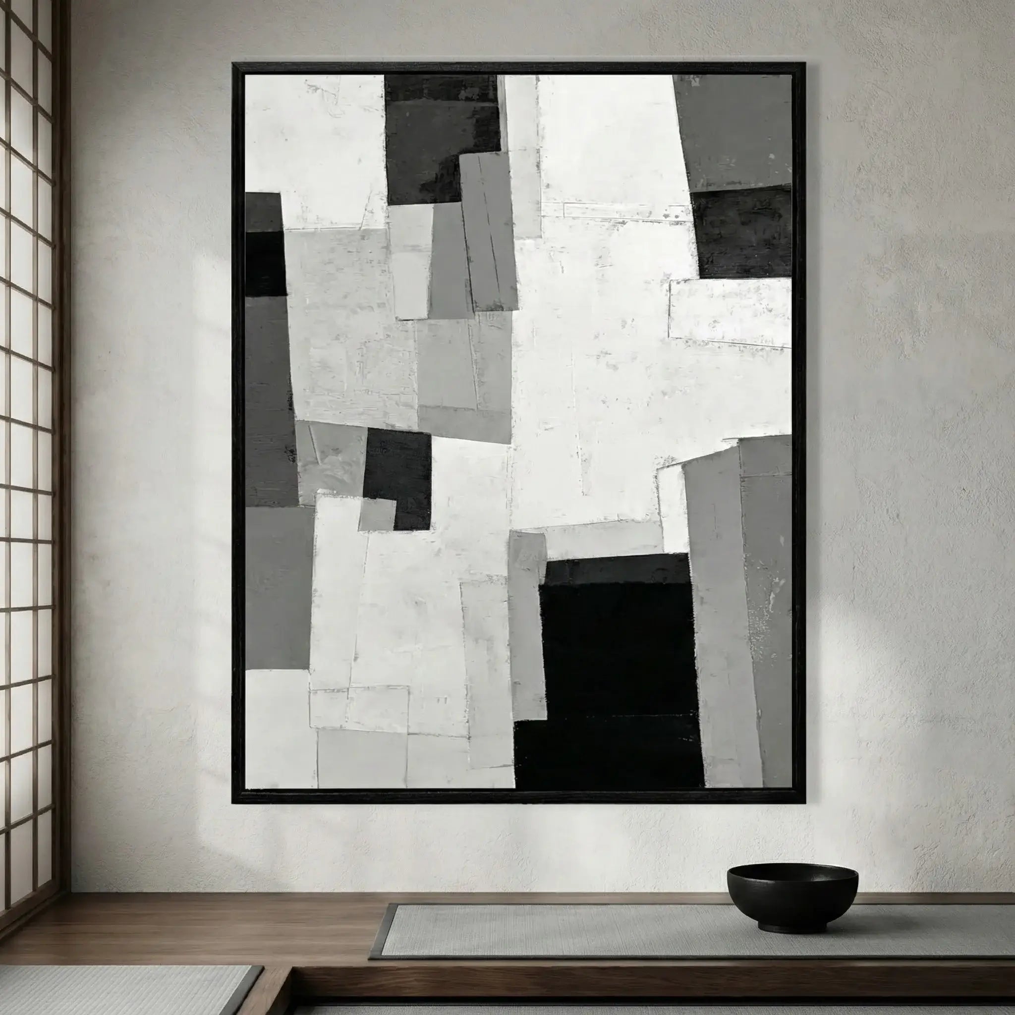 Abstract black and white artwork in a modern interior setting with a bowl on a table.