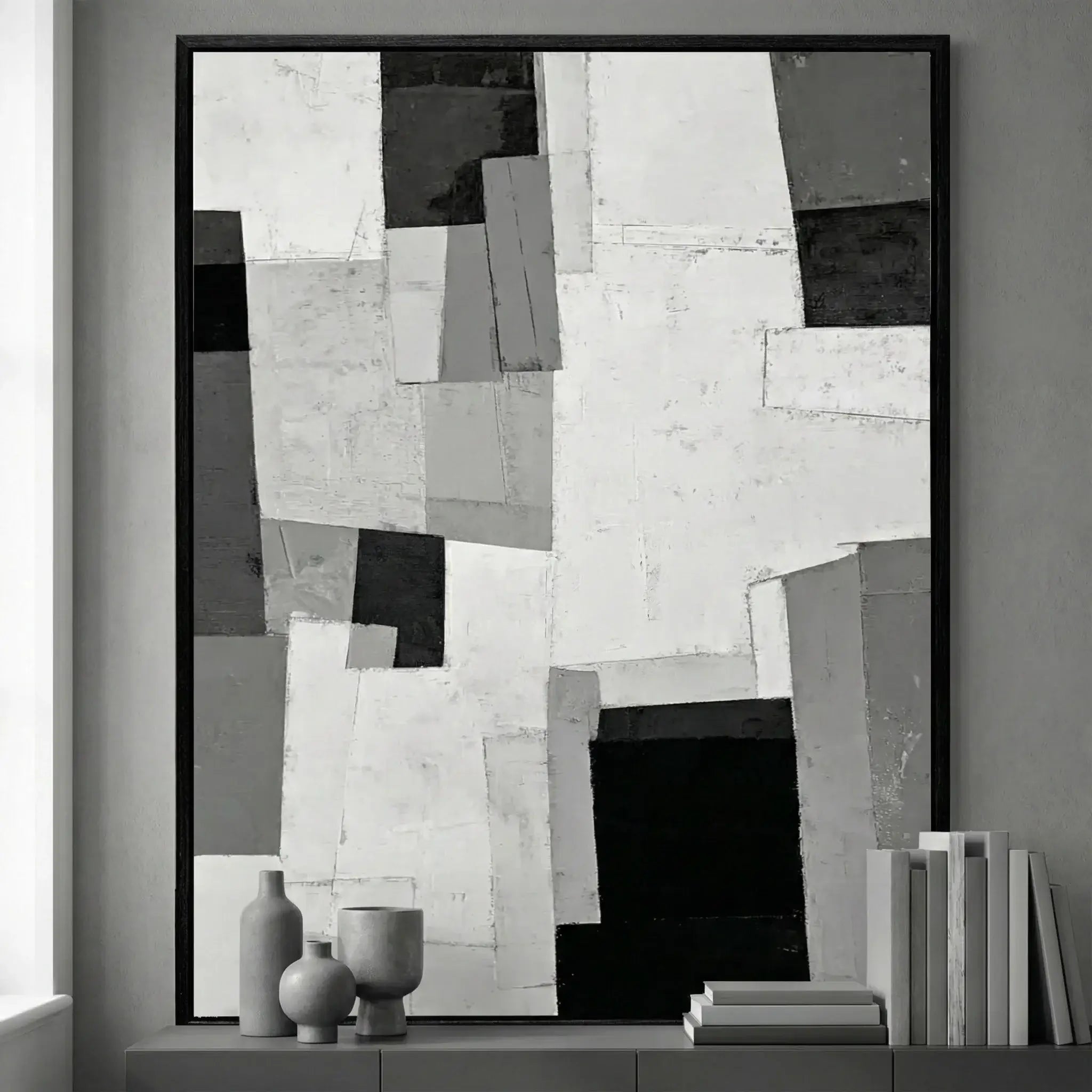 Abstract black and white artwork in a modern interior setting with decorative items.