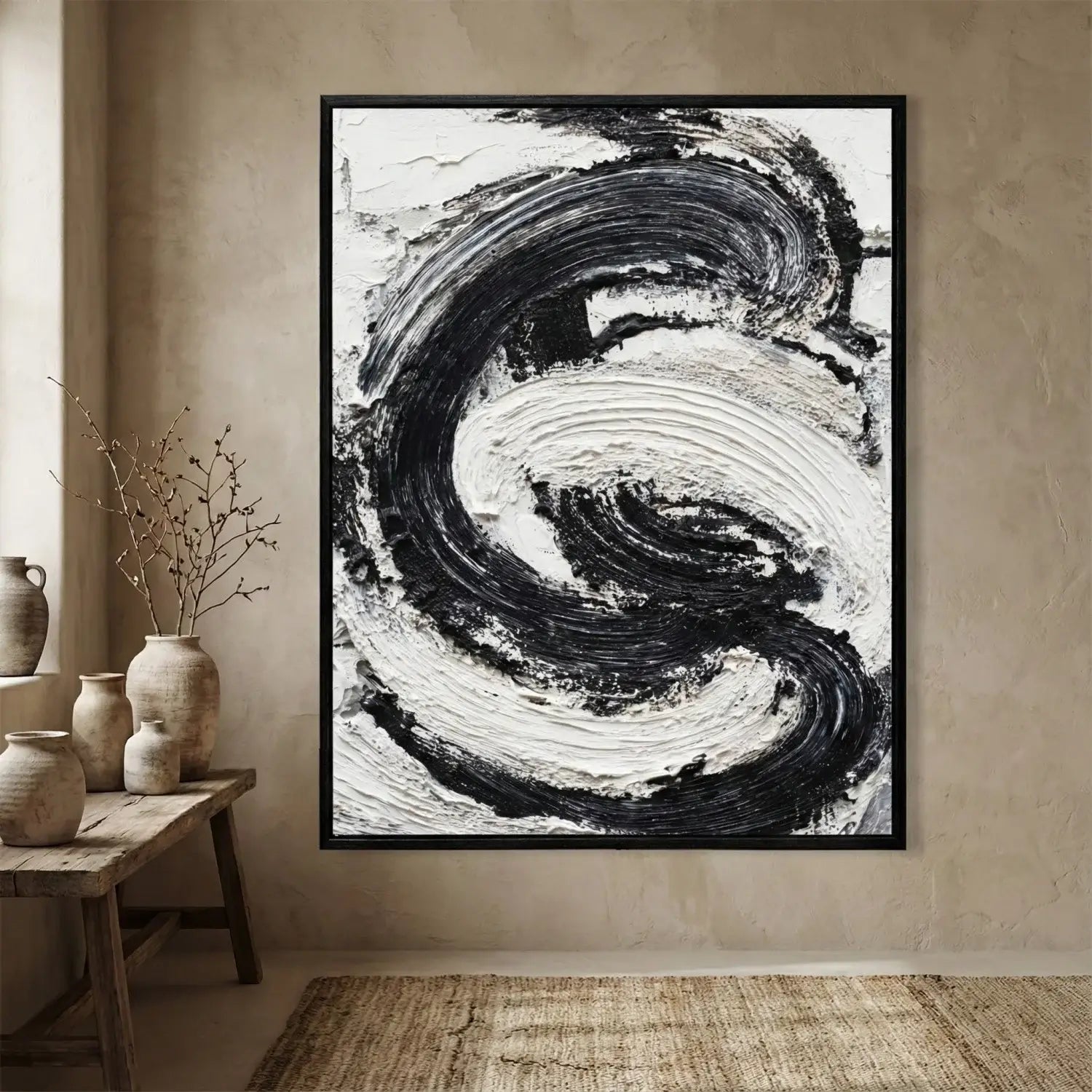 Framed abstract black and white painting on a wall with decorative vases below.