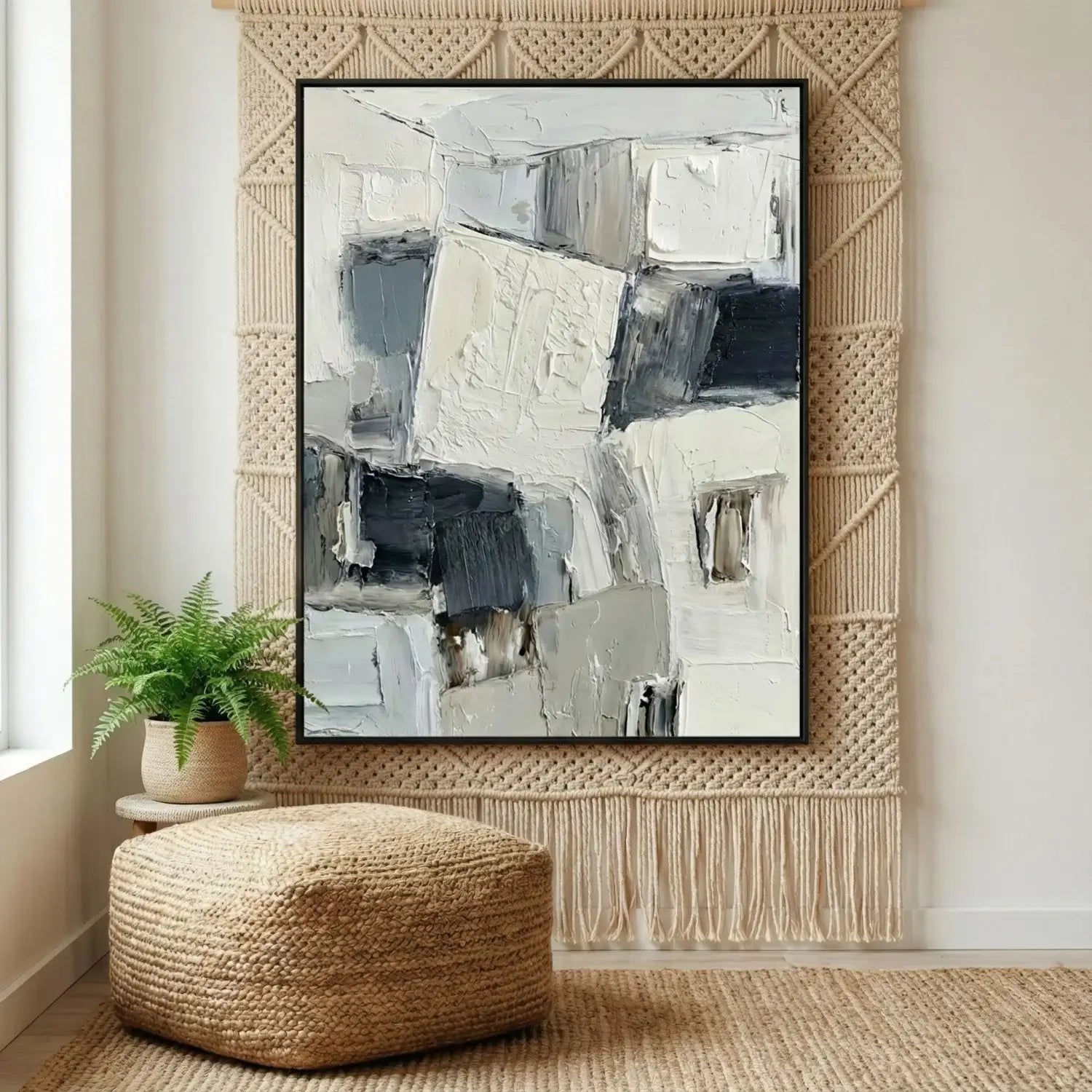 Abstract art piece in a modern interior setting with a woven wall hanging and pouf.