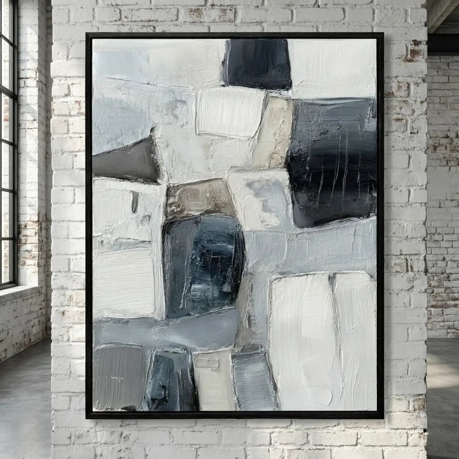 Abstract art piece in a black frame on a brick wall