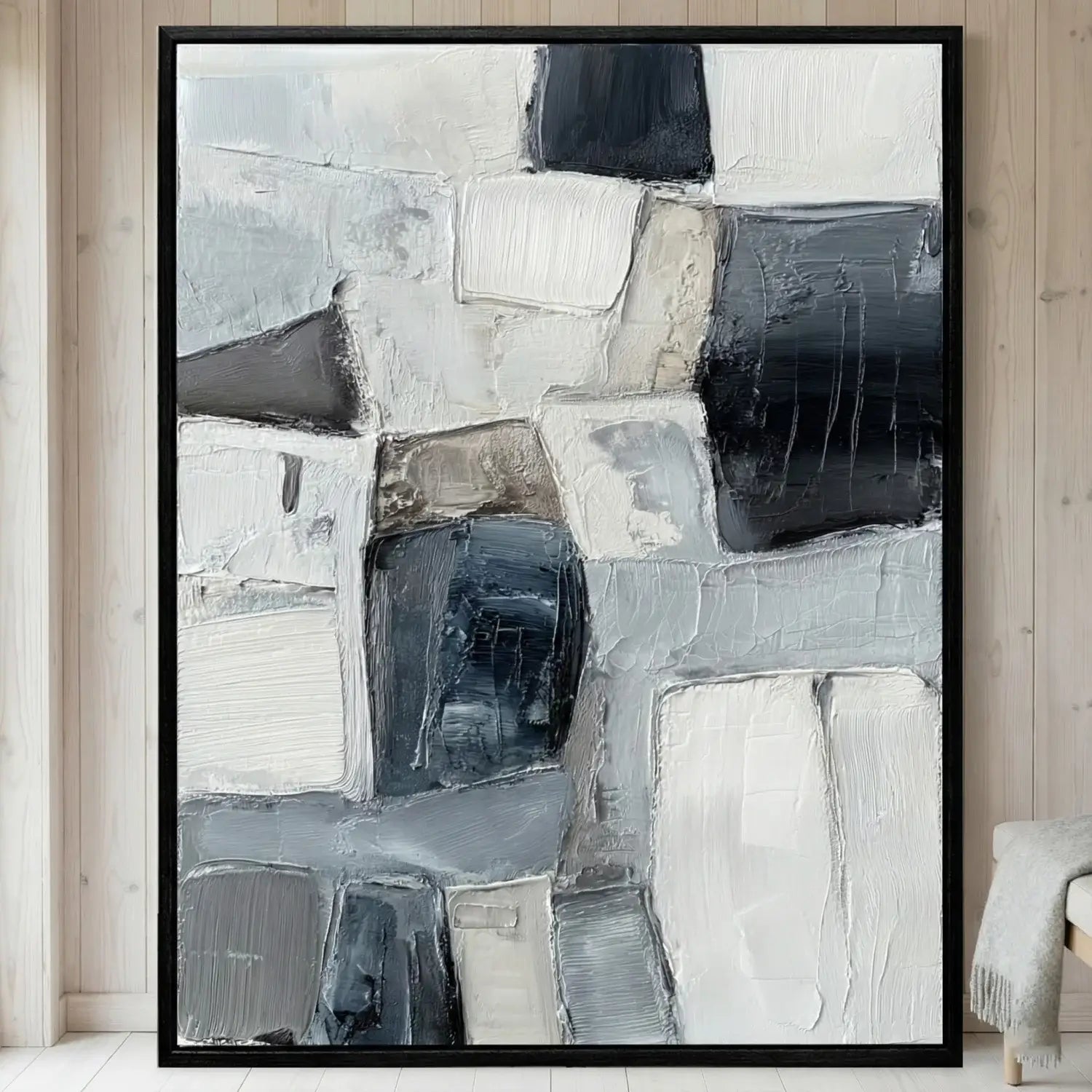 Abstract art painting in a black frame on a wall.