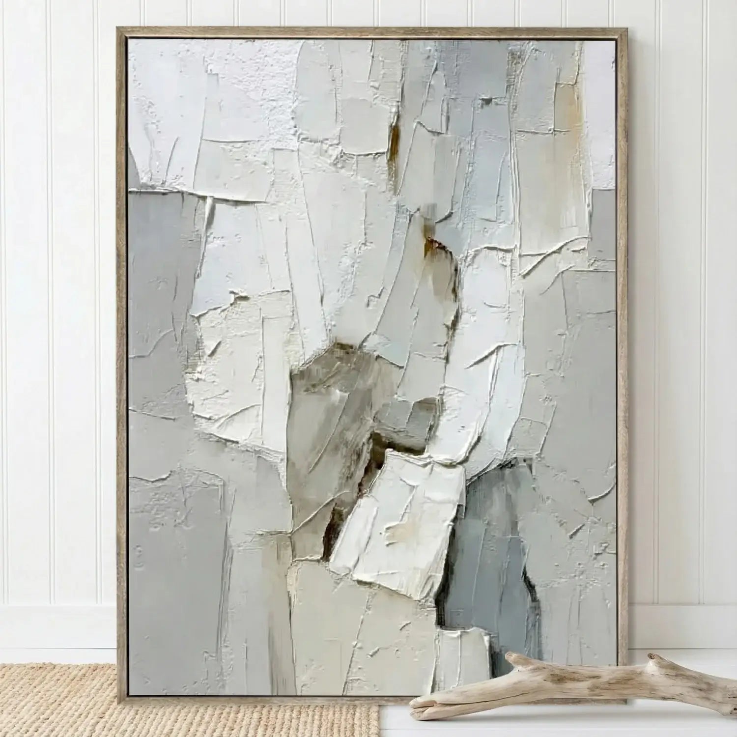 Abstract art piece with textured surface in a wooden frame on a white wall.