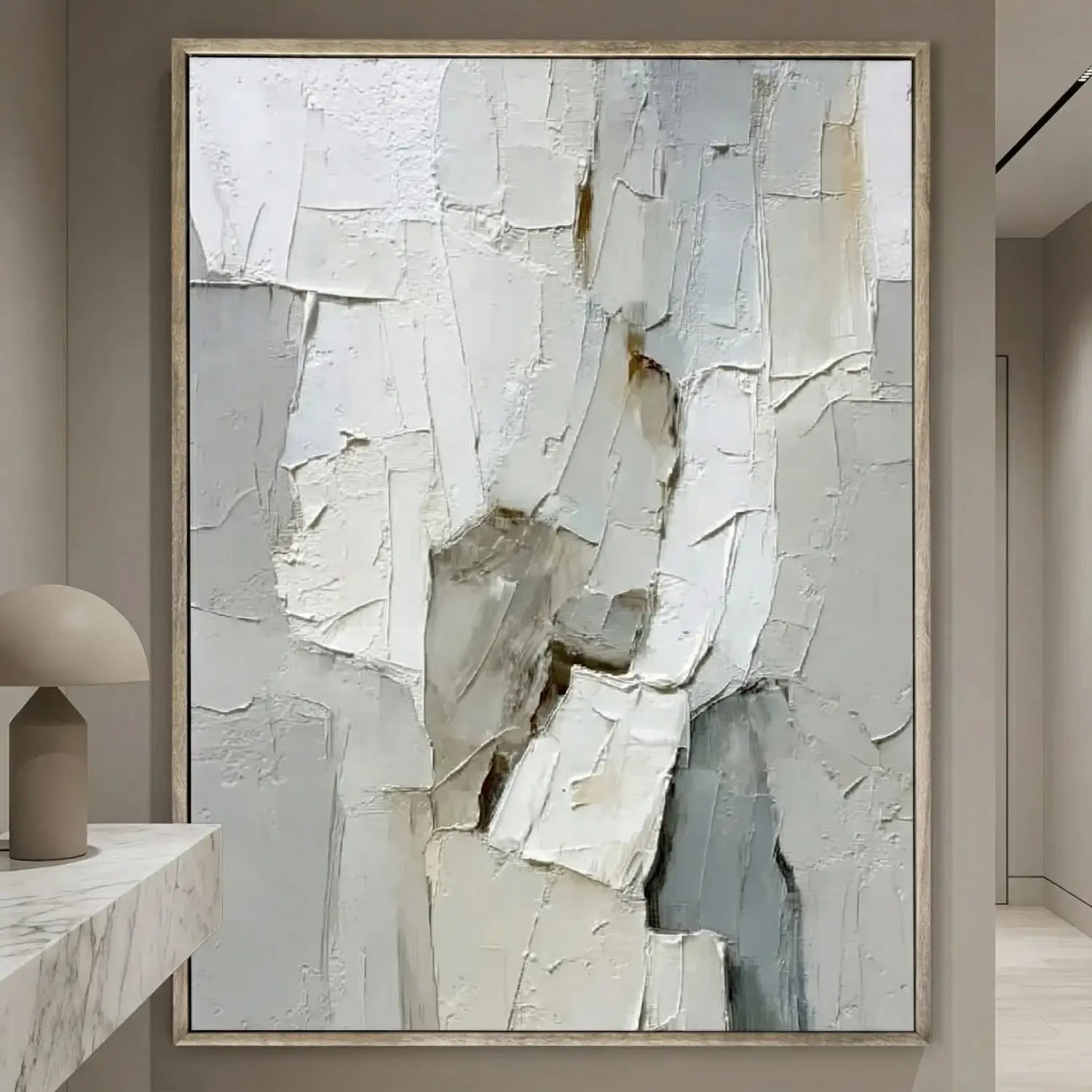 Abstract art piece in a neutral-toned frame on a wall.