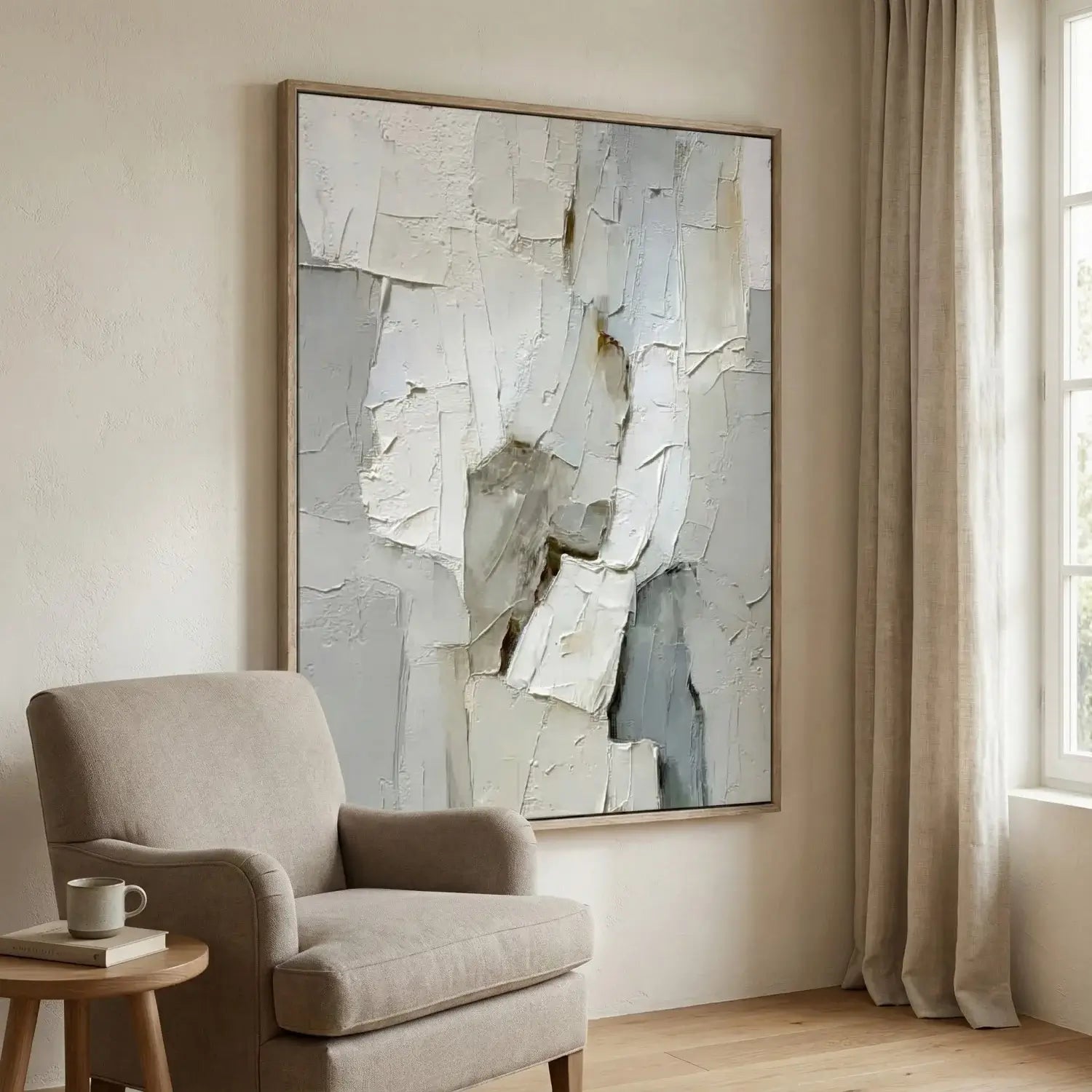 Beige armchair in a room with a large abstract painting on the wall.