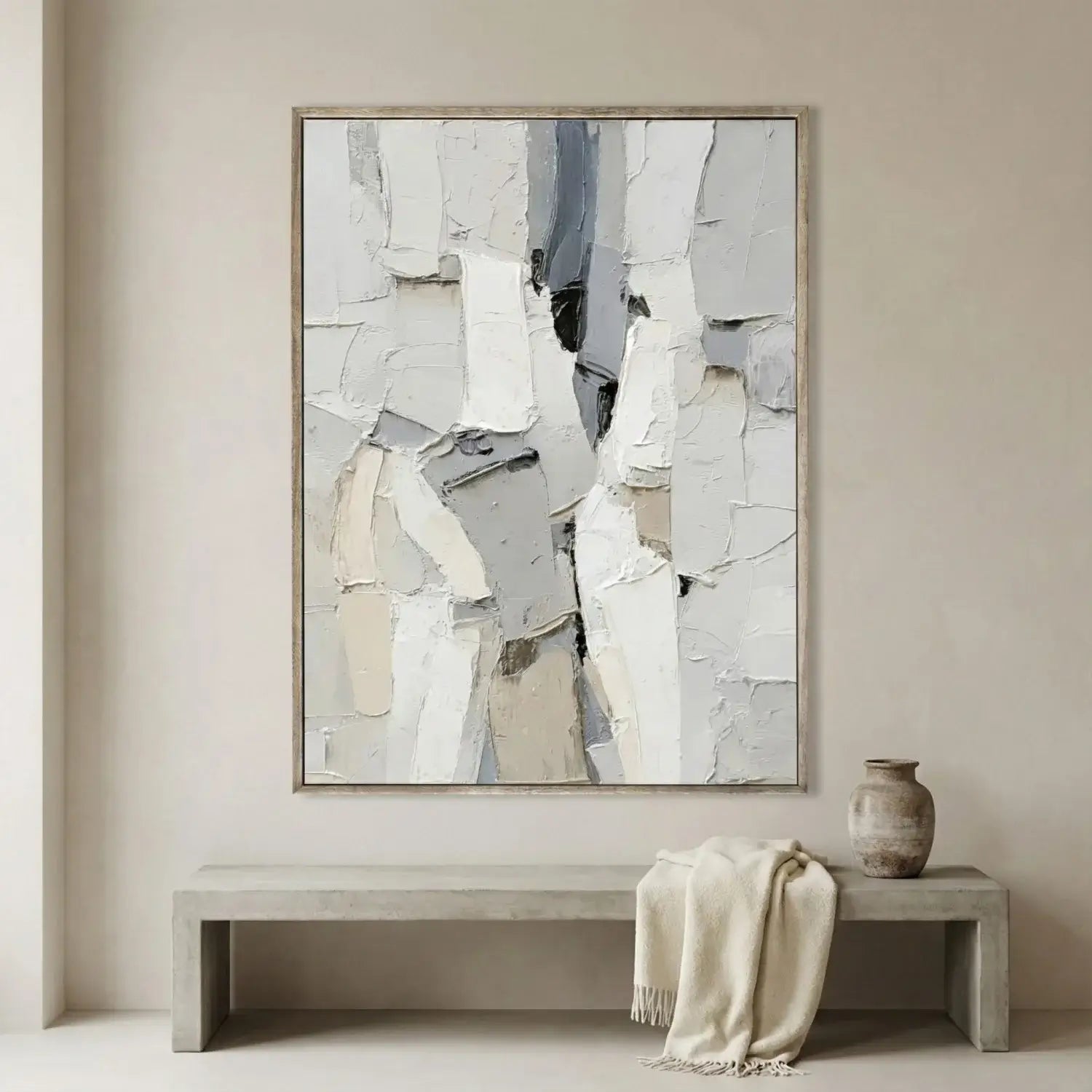 Abstract art piece in a neutral-toned room with a bench and vase.