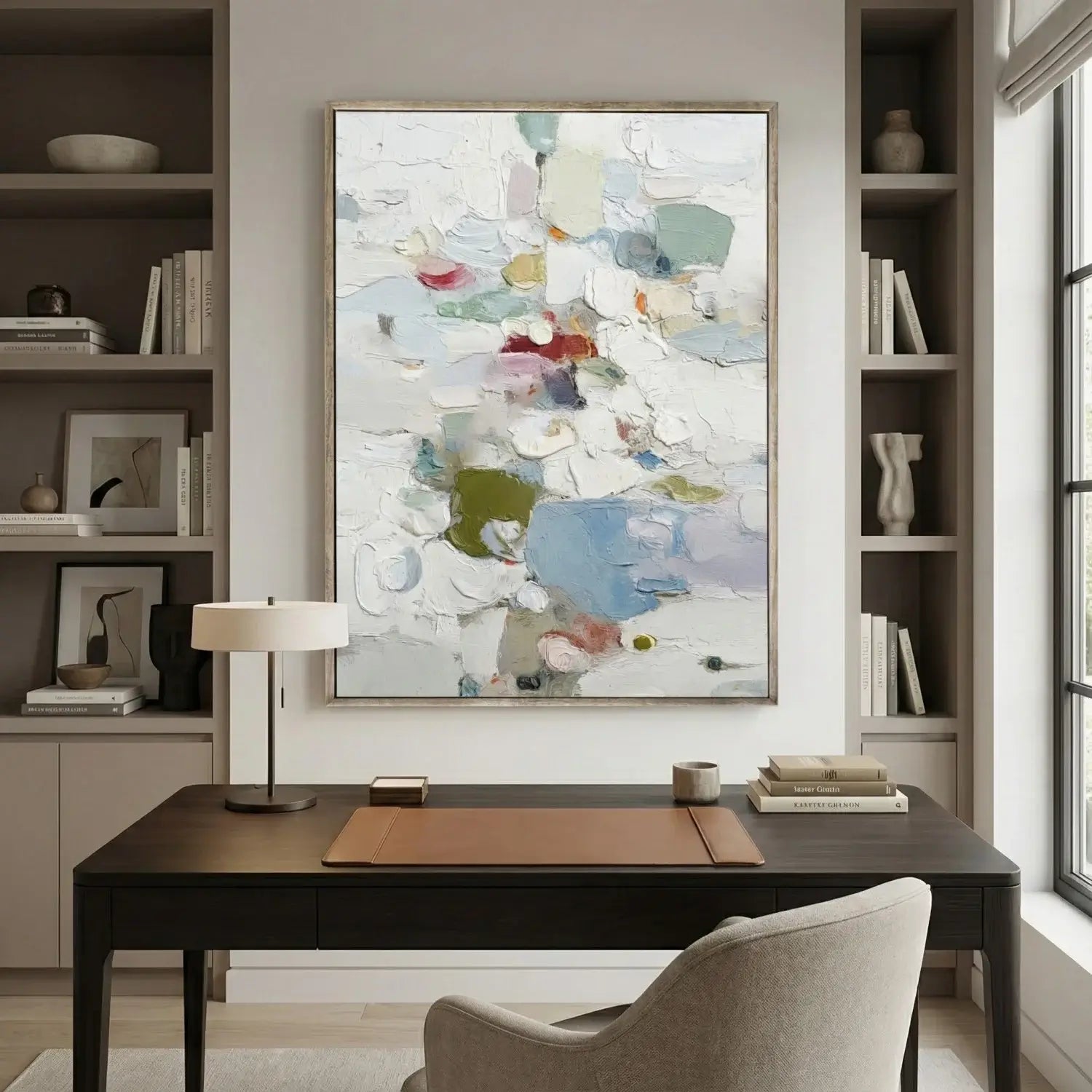 Modern home office with a desk, chair, lamp, and abstract art on the wall.