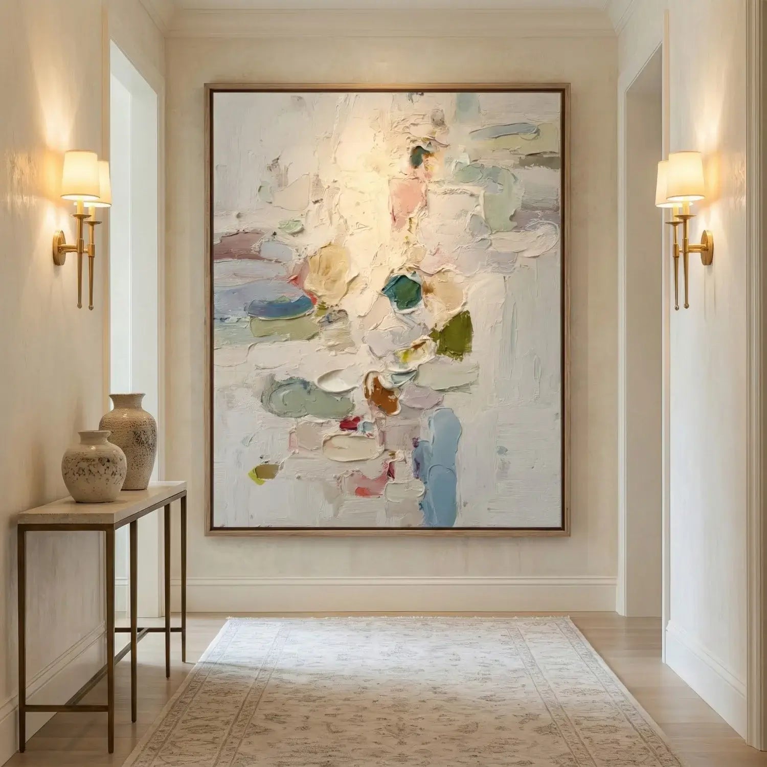 Decorative hallway with abstract painting, vases, and wall lights.