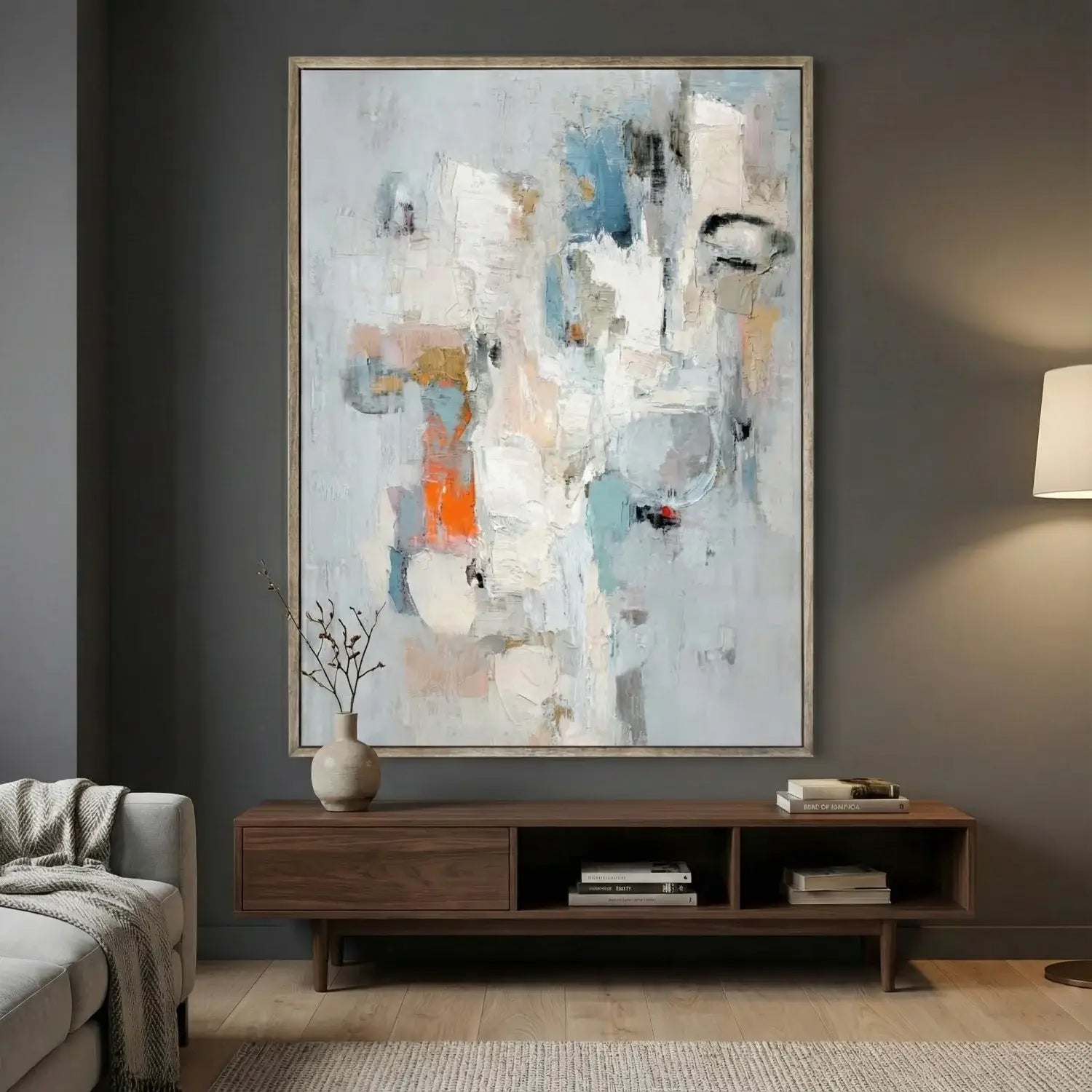 Abstract painting on a wall above a wooden console table in a living room.