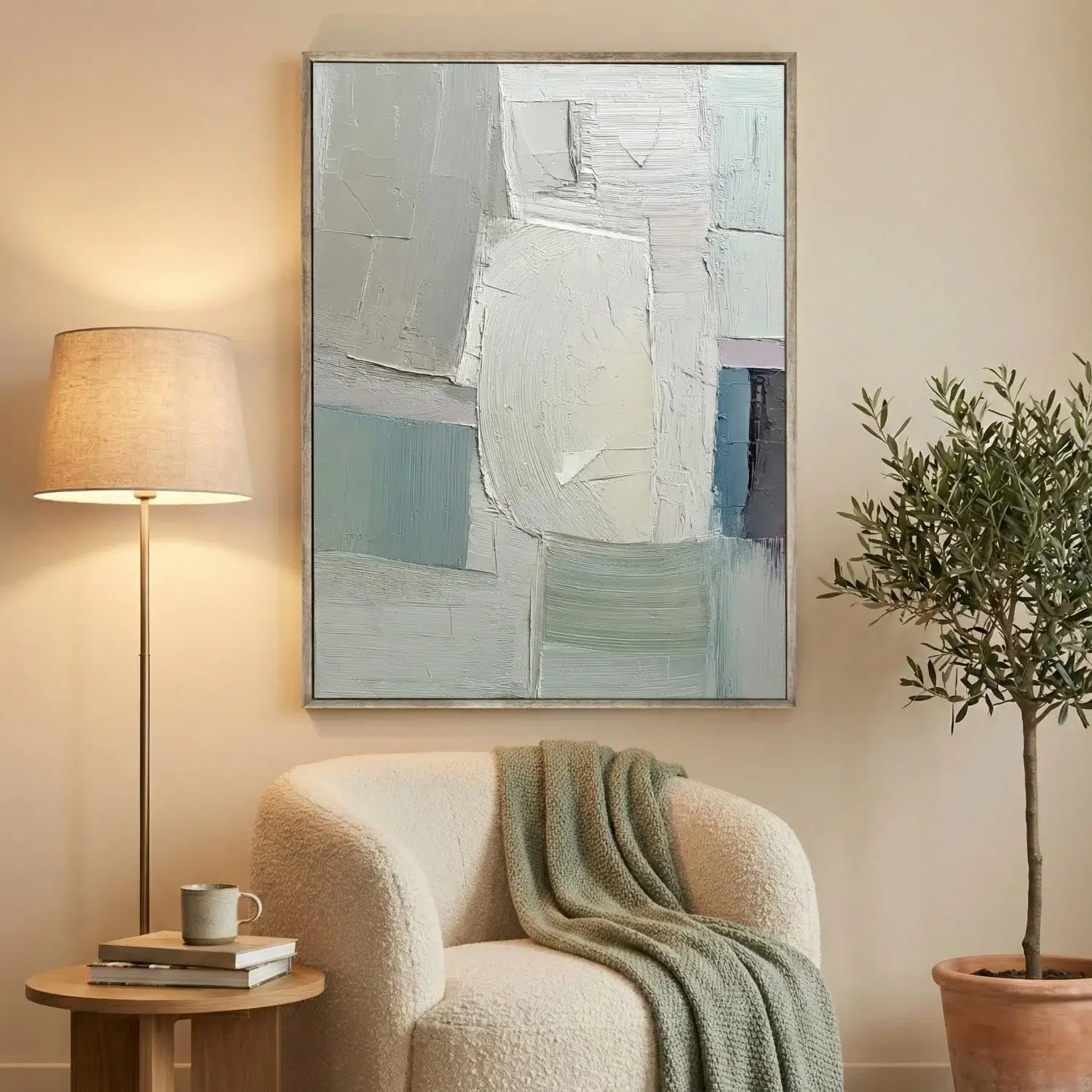 Abstract painting on a wall above a cozy armchair with a lamp and plant in a home setting