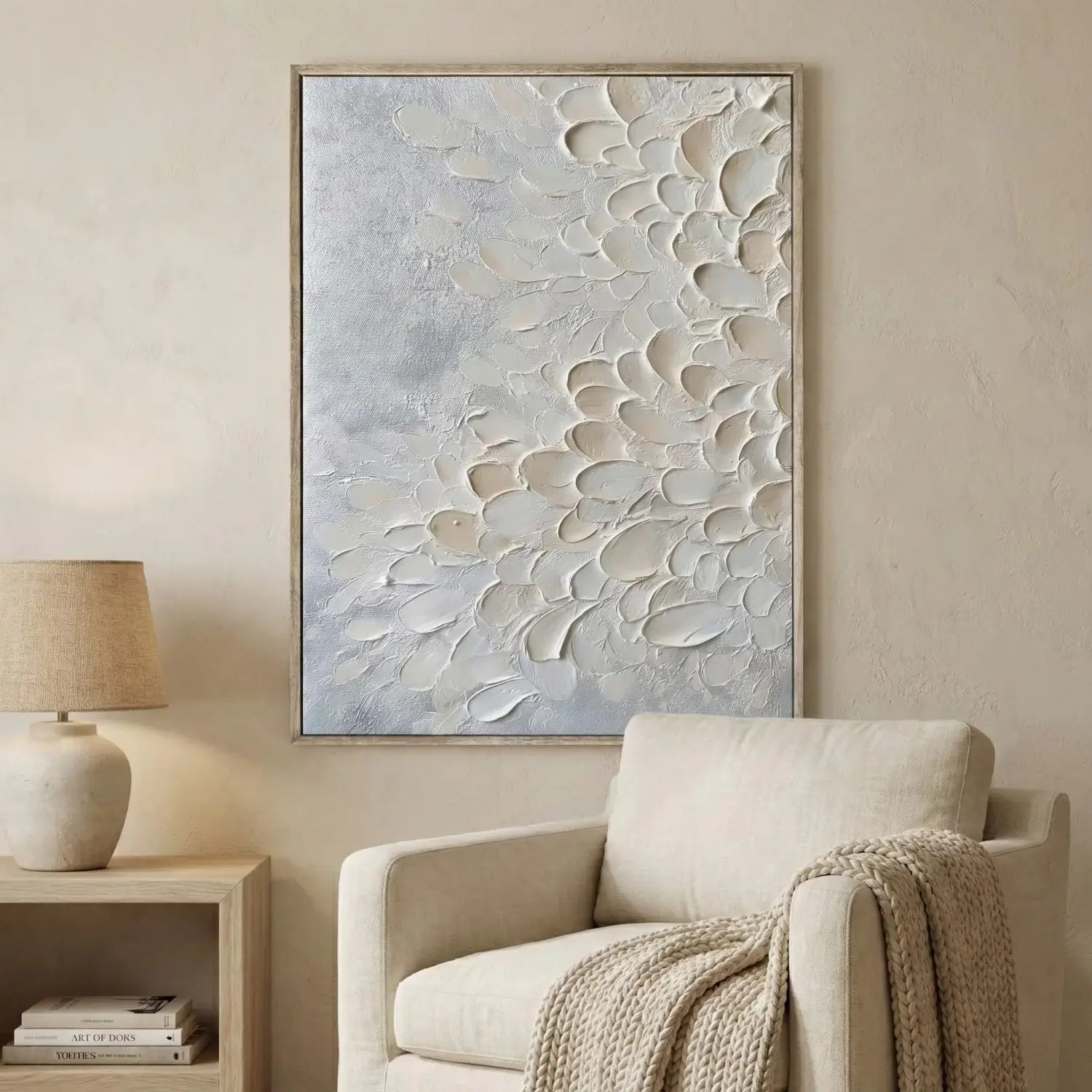 Abstract wall art in a living room with a beige armchair and lamp.