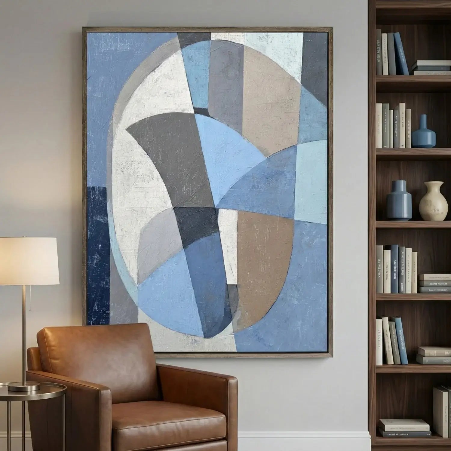 Abstract circular artwork in a living room with a brown armchair and bookshelf.