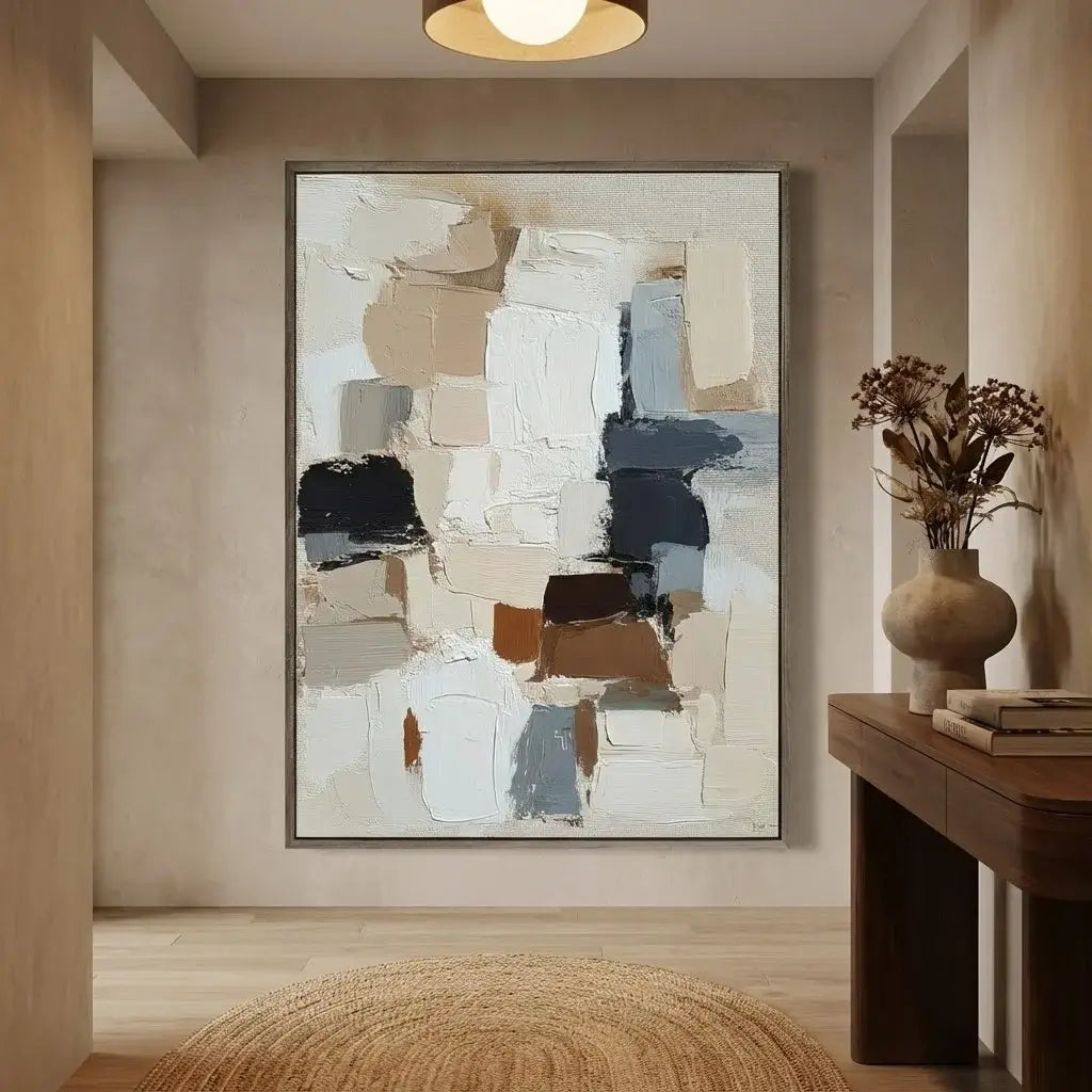Abstract art piece on a wall in a room with a wooden table and vase.