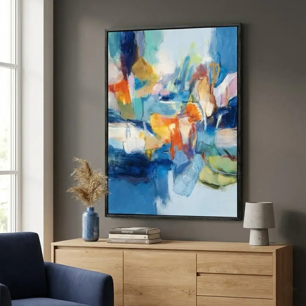 Colorful abstract painting on a wall above a wooden cabinet with decor items.