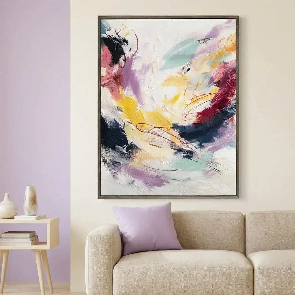 Abstract painting on a wall above a beige sofa with a side table and decorative items.