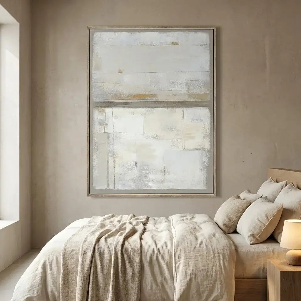 Bedroom with abstract art on the wall and a bed with beige bedding.