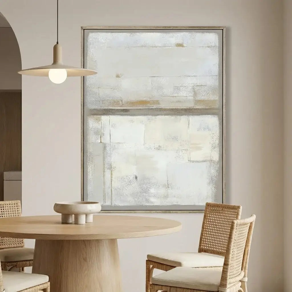 Dining room with wooden table, wicker chairs, and abstract painting on the wall.