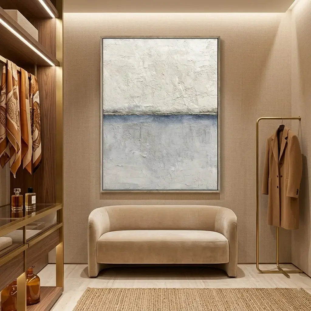 Modern interior with a beige sofa, abstract painting, and coat rack.