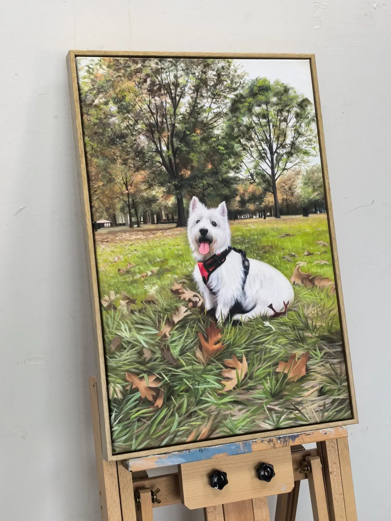 Framed artwork of a white dog on a grassy field with trees