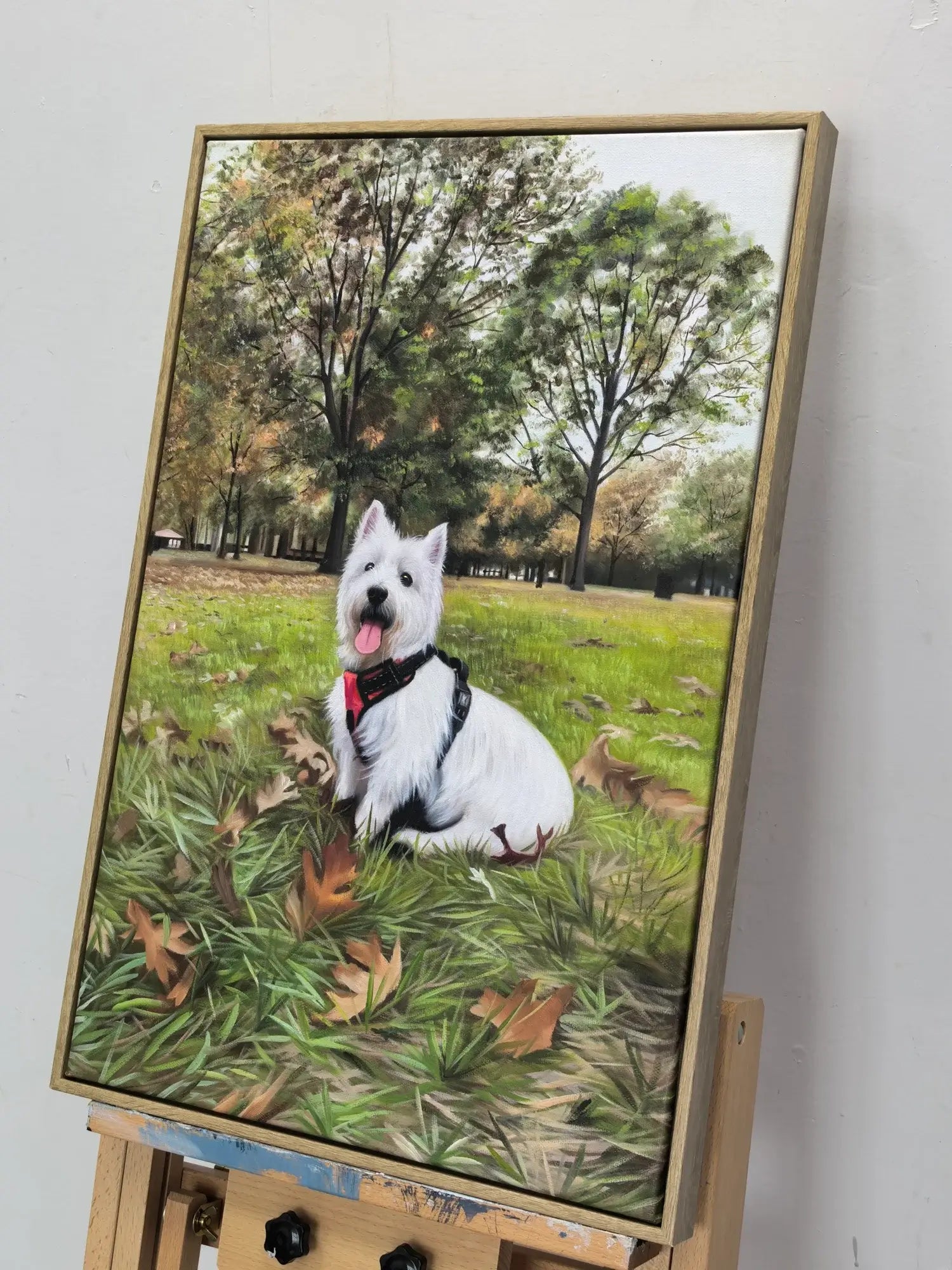 Painting of a white dog on a grassy field with trees in the background