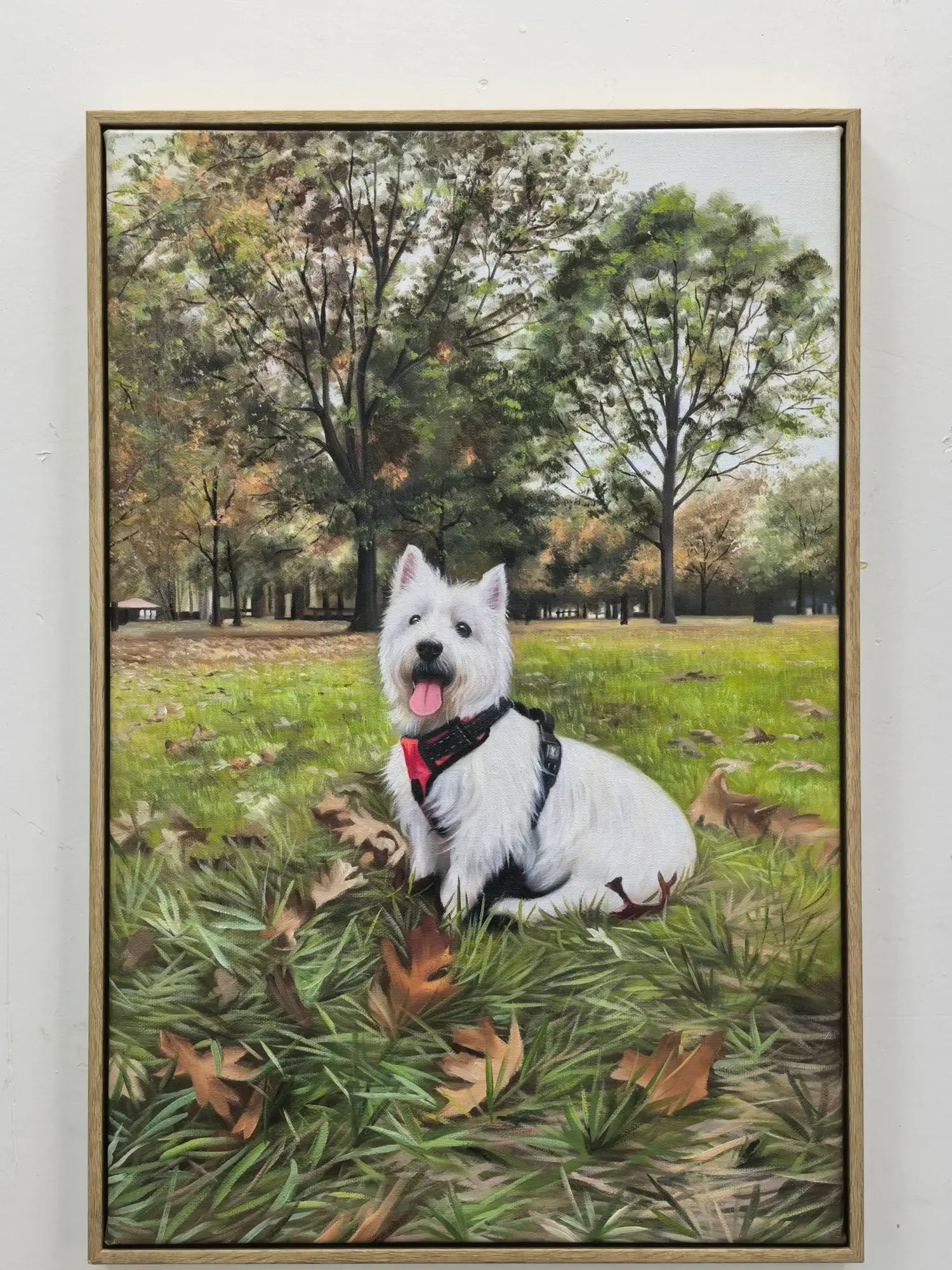 Framed painting of a white dog sitting in a park with trees and grass.