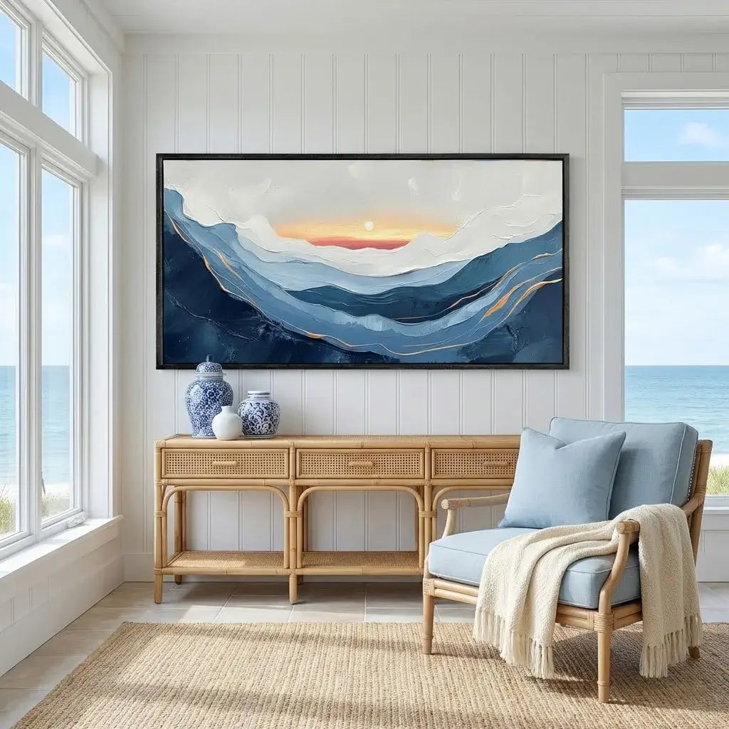 Living room with a large abstract painting, wooden console table, and wicker chair by a window with ocean view.