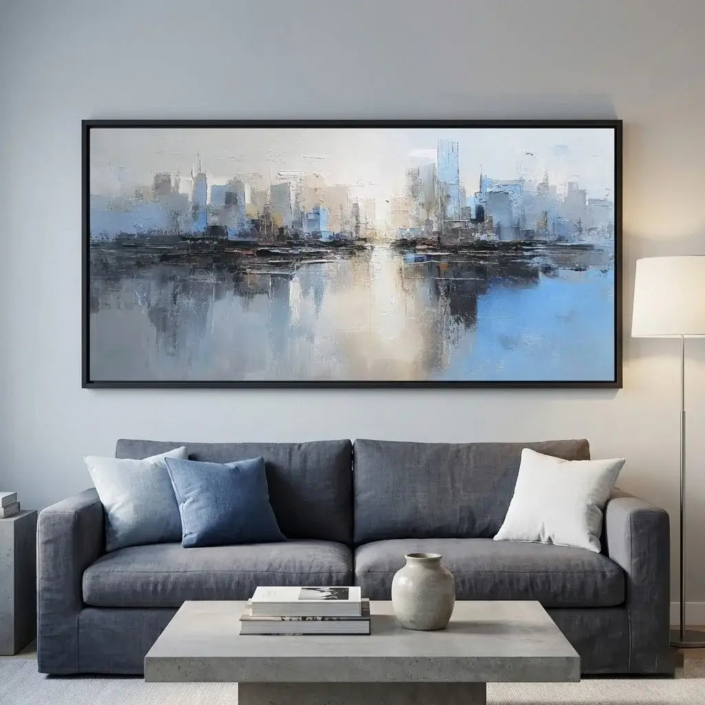 Living room with a gray sofa, coffee table, and abstract cityscape painting on the wall.