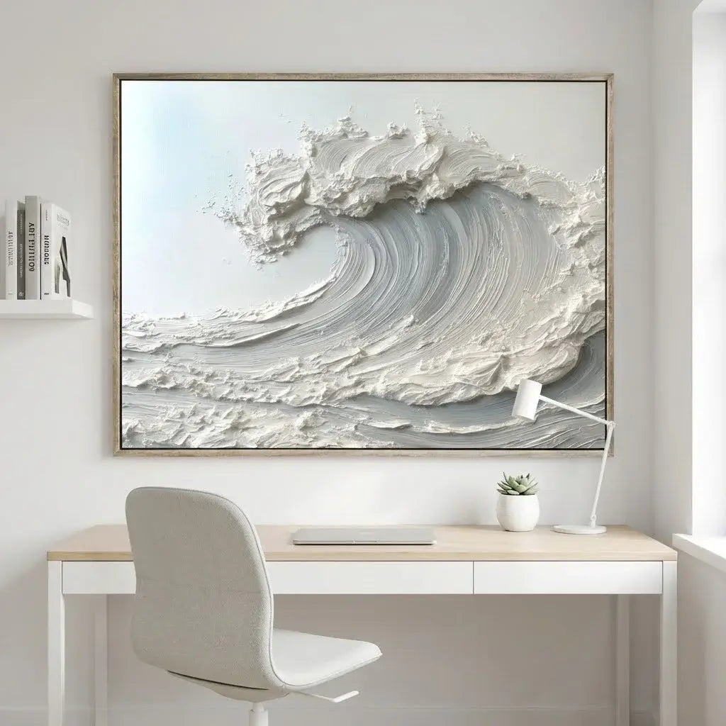 Framed abstract artwork of a wave above a desk with a chair and lamp.