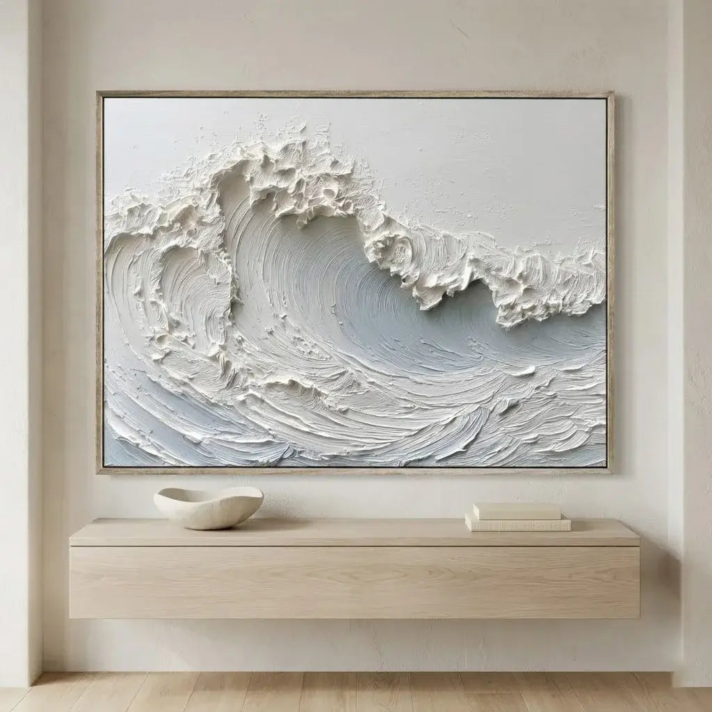 Framed artwork of a wave on a wall above a wooden console table.