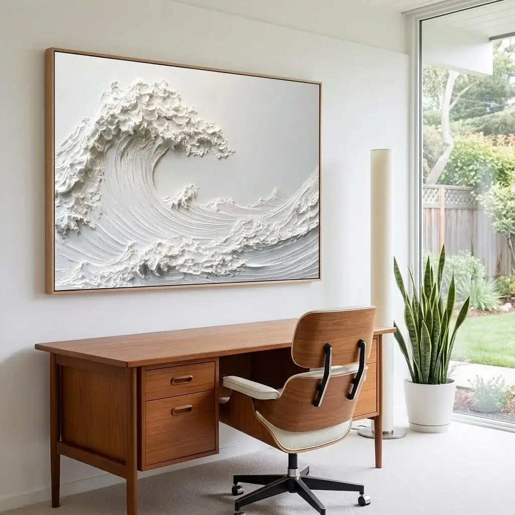 Wooden desk with chair in a room with a large framed artwork of a wave on the wall.