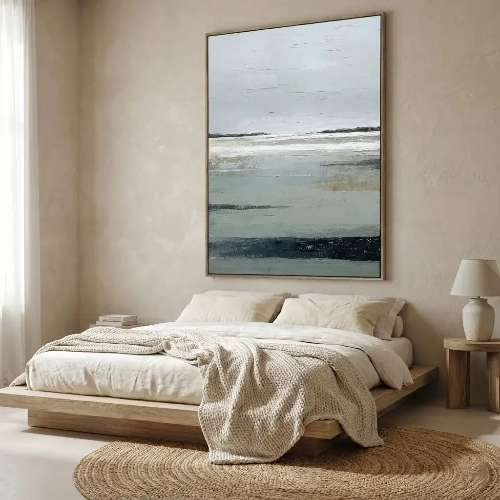 Modern bedroom with a bed, abstract painting, and side table.