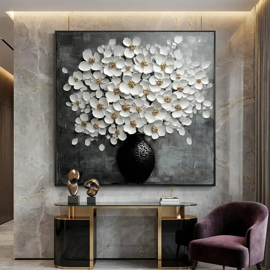 Decorative wall art of white flowers in a black vase on a marble wall, with a modern interior setting.