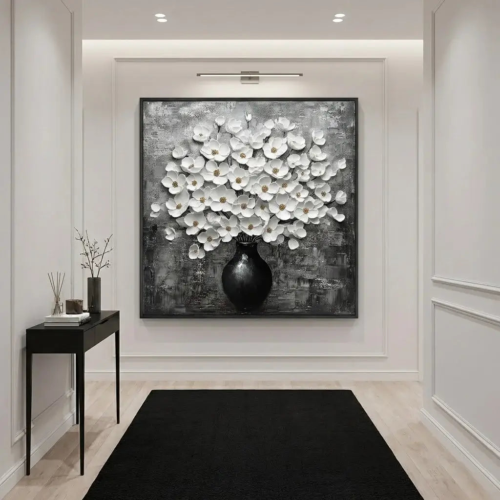 Modern interior with a large abstract painting of white flowers in a black vase on a gray background.