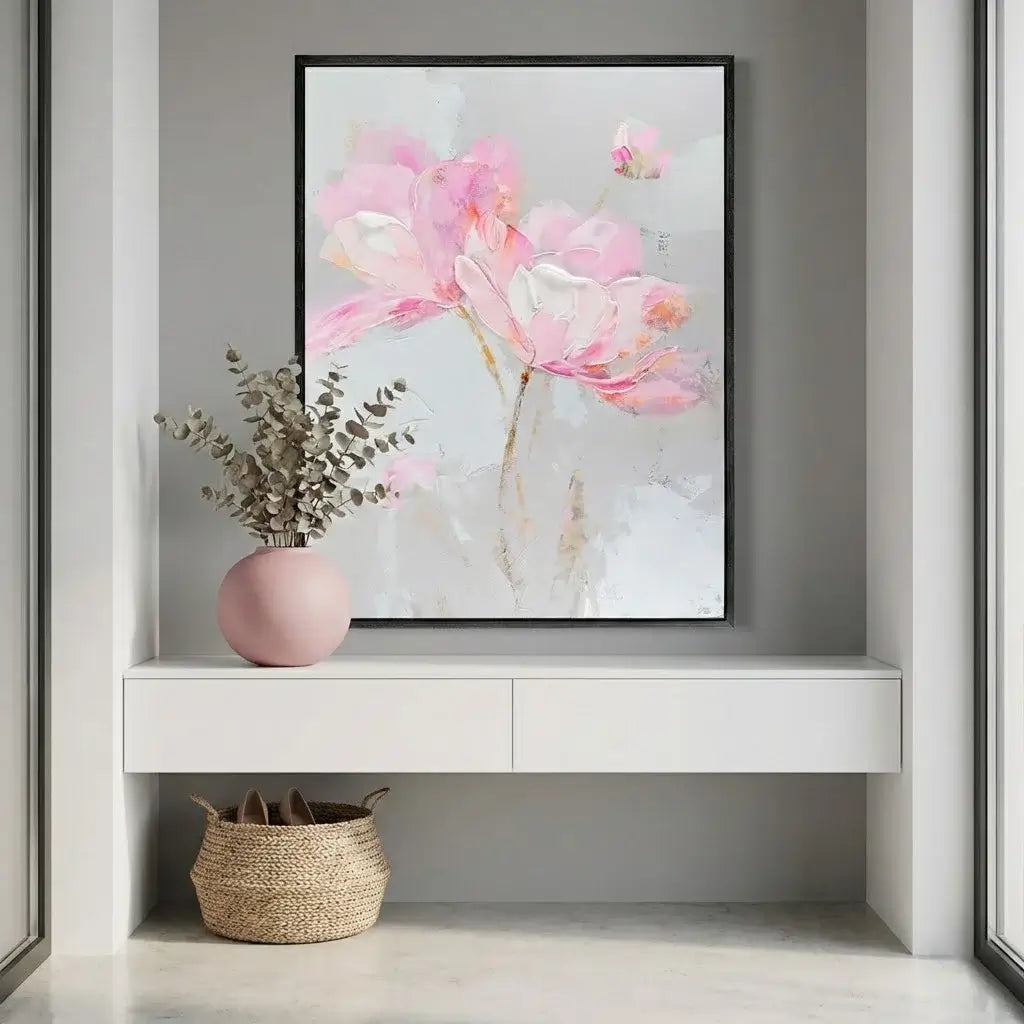 Framed floral artwork on a wall above a white console table with decorative items.