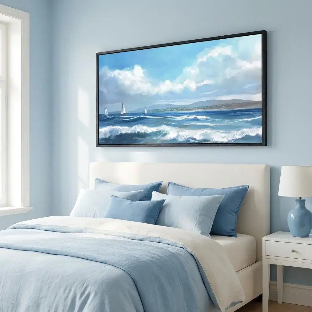 Bedroom with a large seascape painting on the wall, light blue bedding, and a lamp.