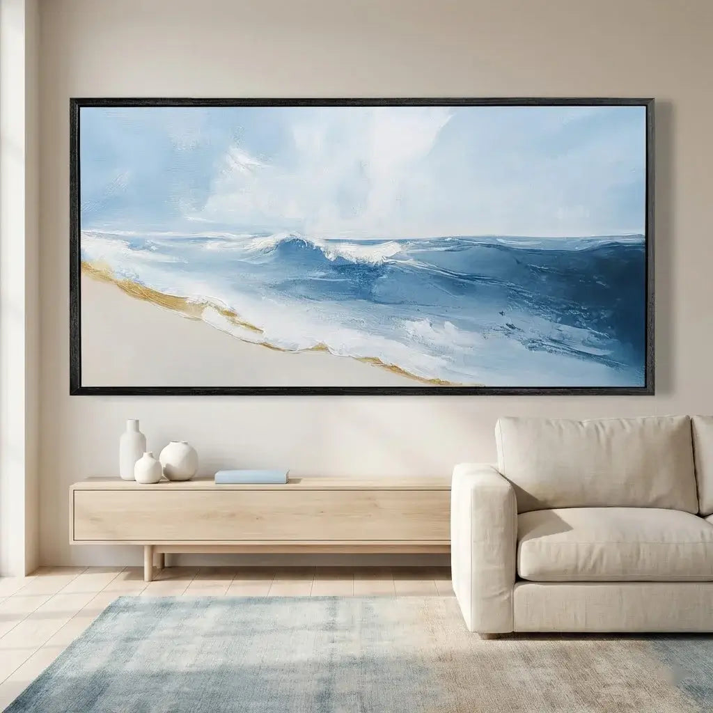 Framed artwork of a beach scene above a living room with a sofa and coffee table.
