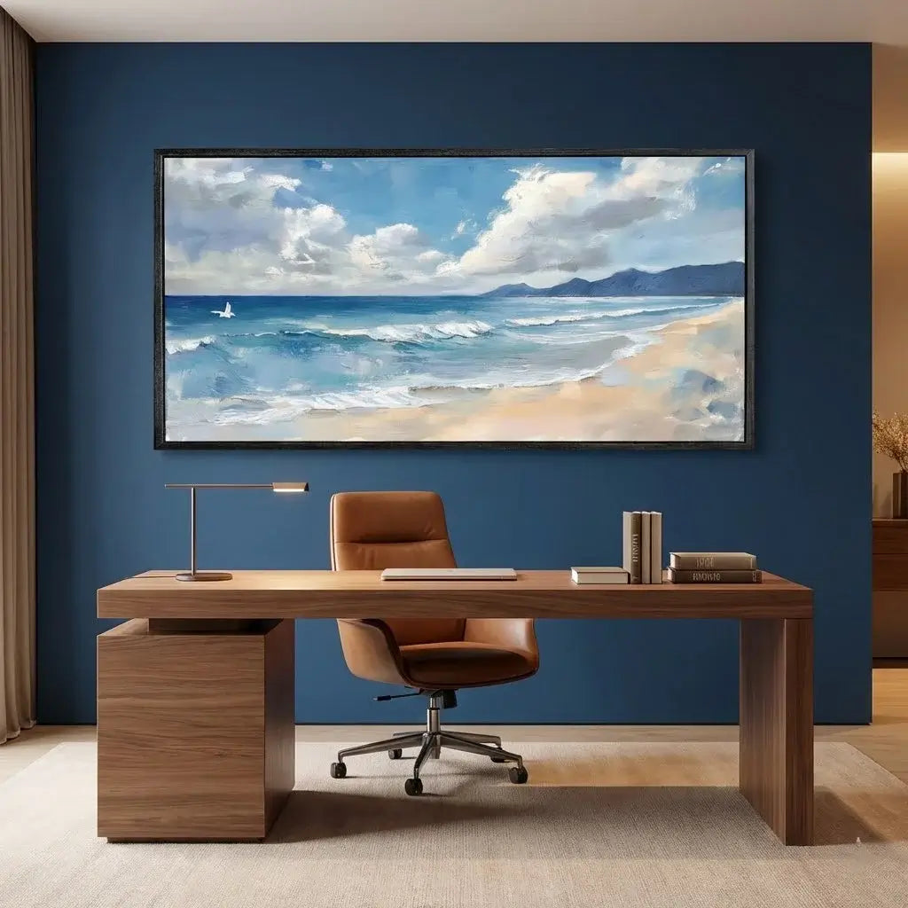 Modern office setup with a wooden desk, leather chair, and large framed beach scene on a blue wall.