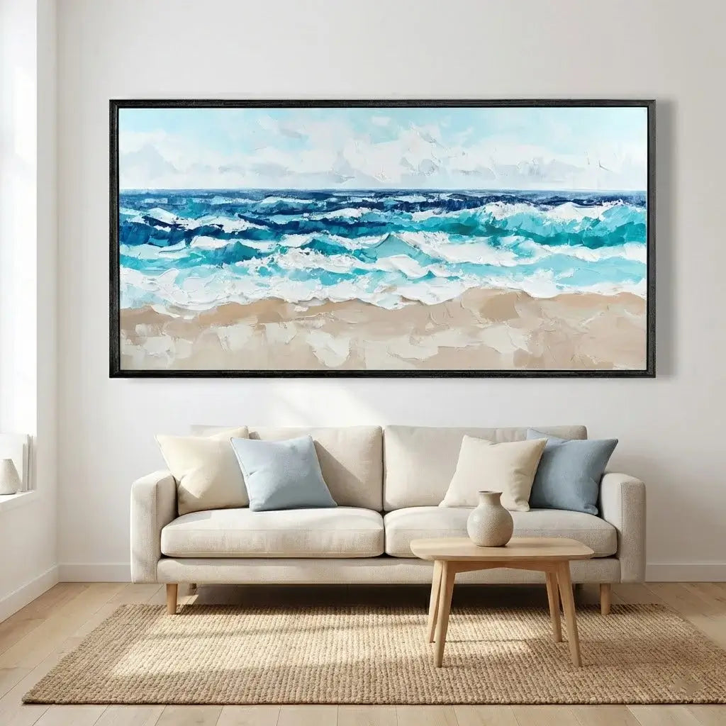 Framed beach scene painting above a beige sofa in a living room.