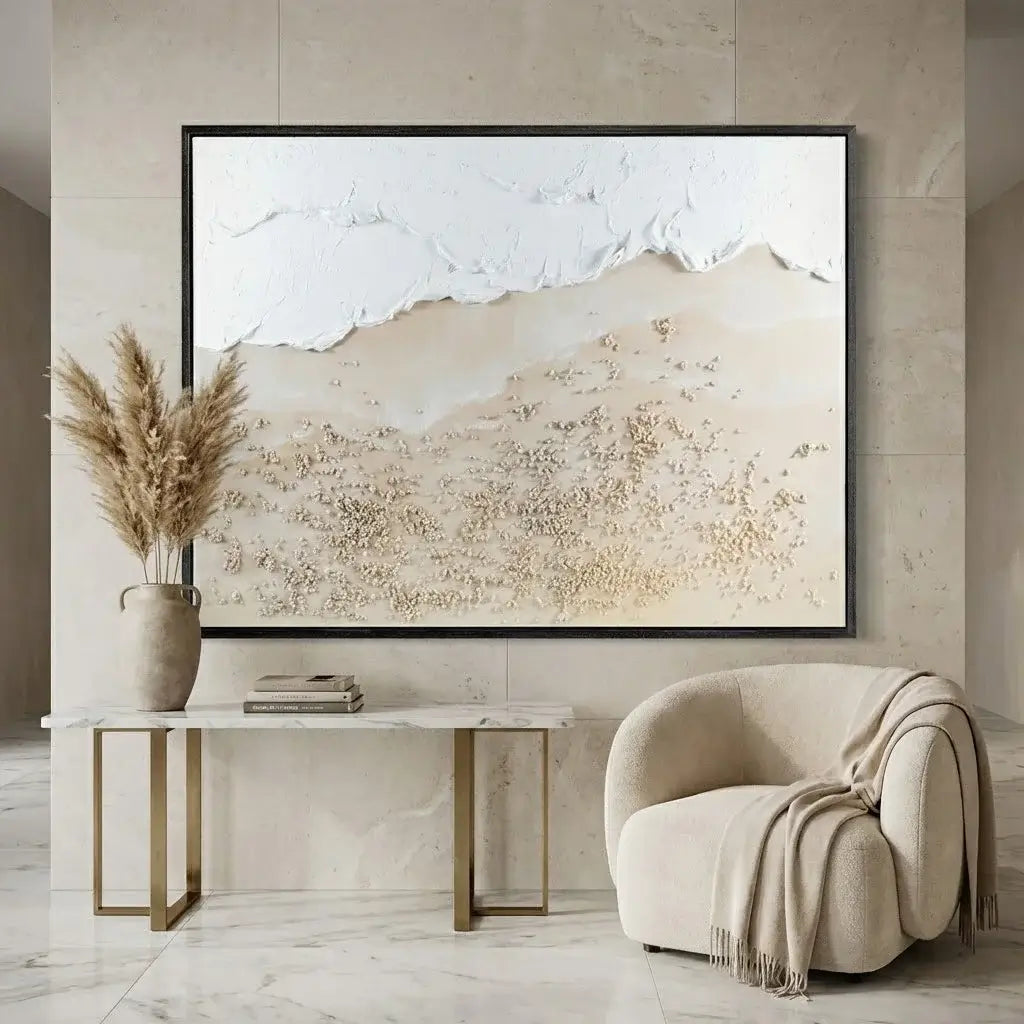 Beige abstract landscape painting on a wall above a marble table and armchair.