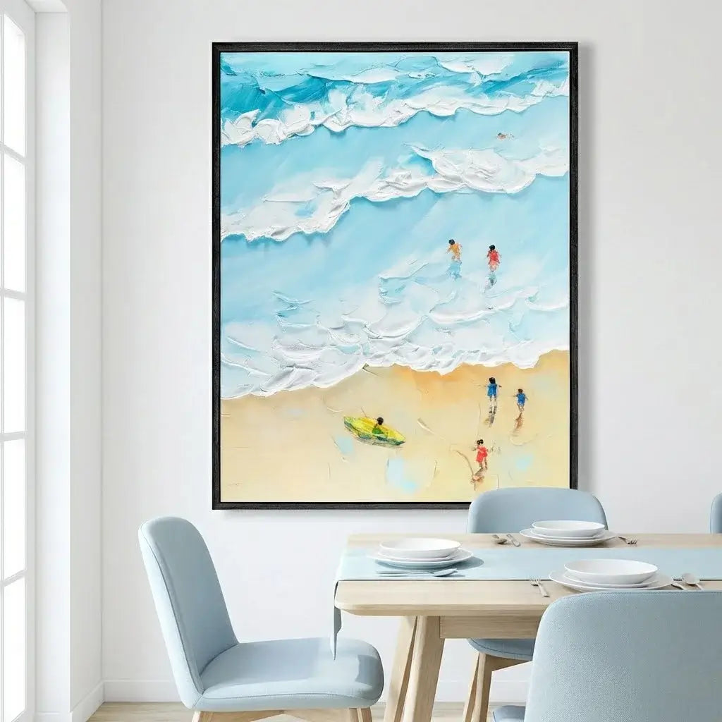 Framed artwork of people on a beach above a dining table with chairs.