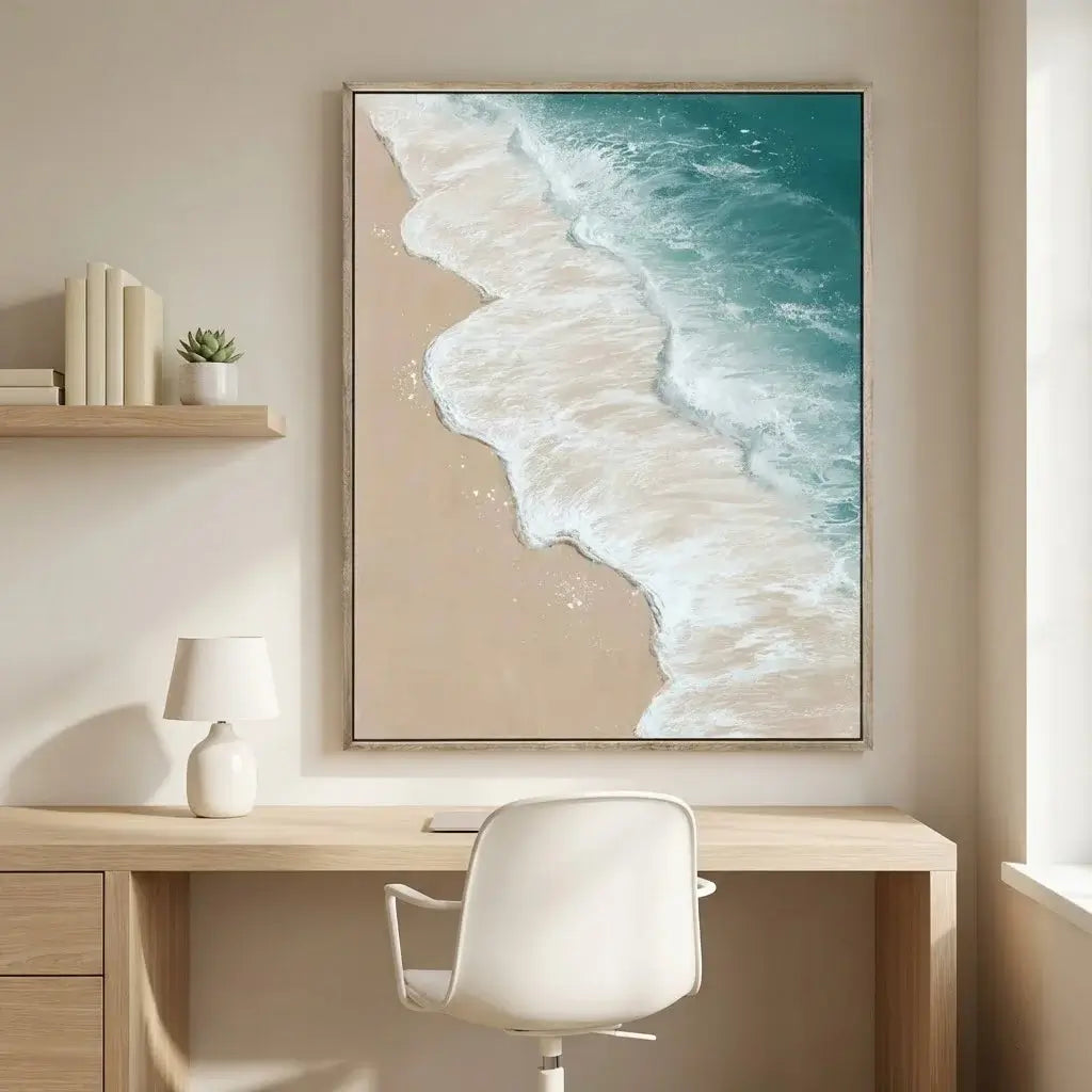 Beach scene artwork on a wall above a desk with a chair.
