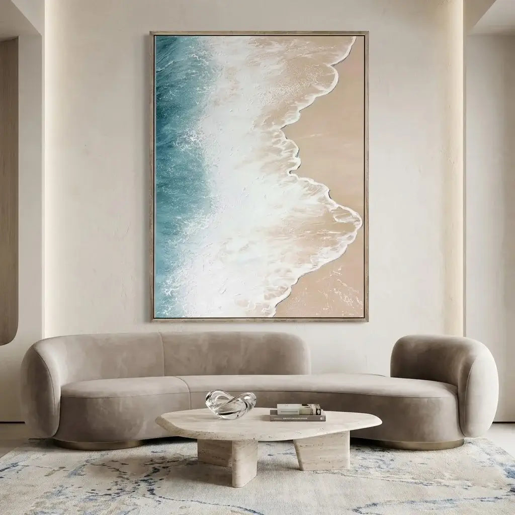 Modern living room with a beige sofa, round coffee table, and large abstract wall art of a beach scene.