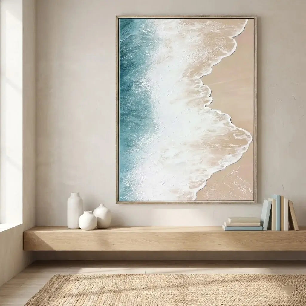 Framed artwork of a beach scene on a wall above a wooden shelf.