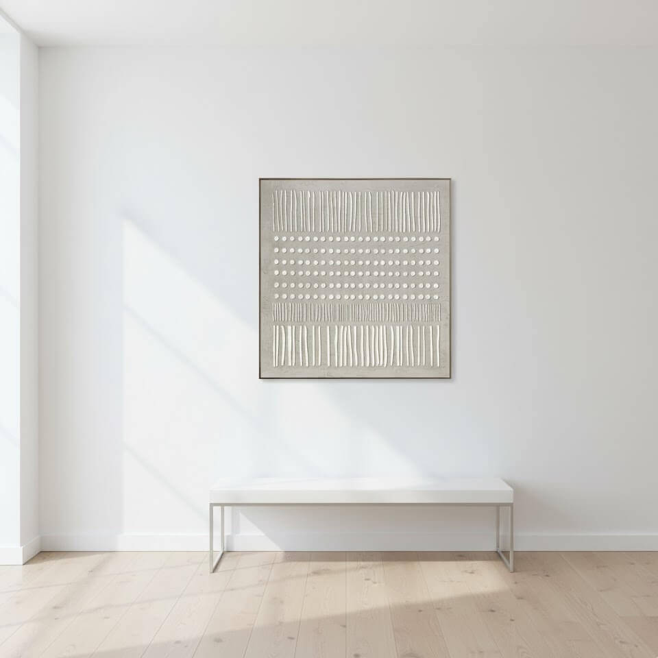 Abstract art piece on a white wall above a white table